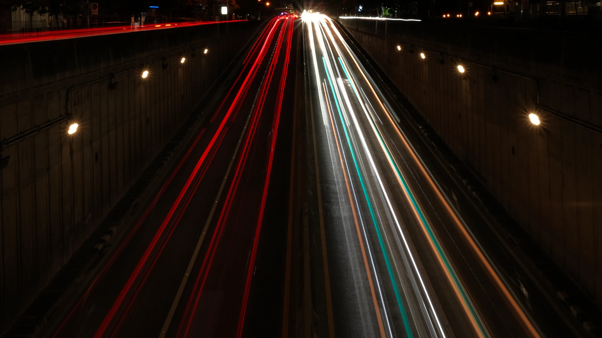 Long-exposure light trails on a highway at night.